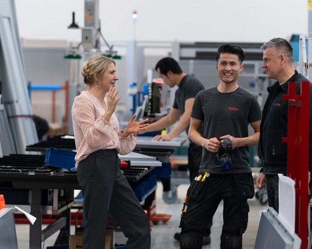 En kvinna och två män står och pratar